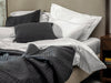 bed with an organic cotton quilted bed spread in black with a geometric design
