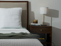 bed with an organic cotton quilted bedspread in white